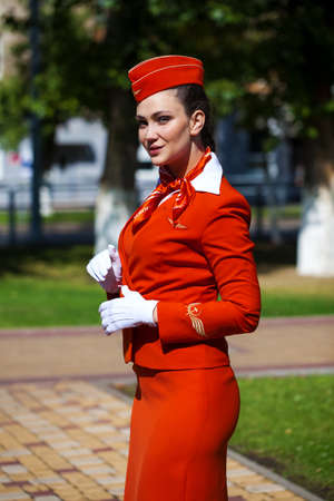 RUSSIA, SAMARA: 08 AUGUST 2019. Beautiful stewardess dressed in official red uniform of Aeroflot Airlines, Summer street outdoorsのeditorial素材