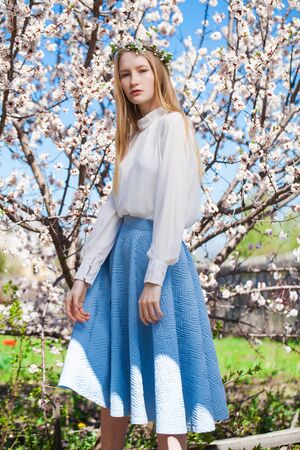 Close up portrait of a young blonde woman posing in spring parkの写真素材