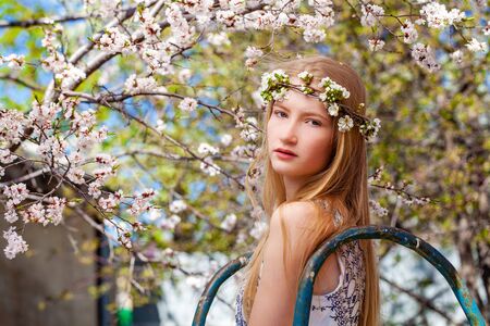 Close up portrait of a young blonde woman posing in spring parkの写真素材