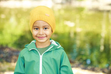Close up portrait of little boy in autumn park