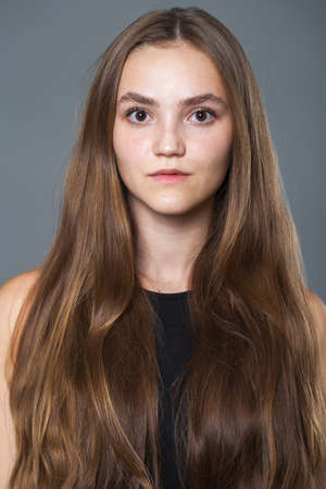 Portrait of a young beautiful brunette girl, indoorの写真素材