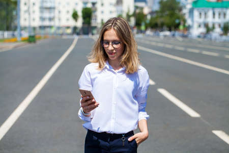 Blond elegant successful business girl in white shirt to go and touch pad during a break sitting...