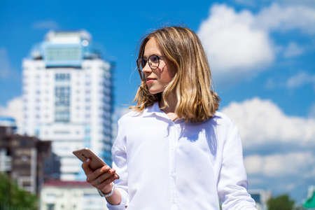 Blond elegant successful business girl in white shirt to go and touch pad during a break sitting...