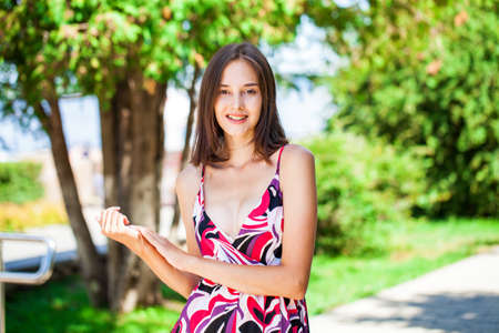 Full body portrait of a young brunette woman in orange skirt walking in autumn park