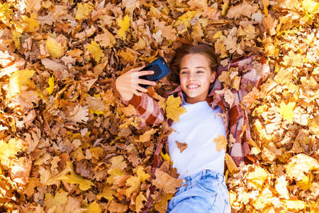 Full length portrait of a young beautiful girl posing in an autumn park