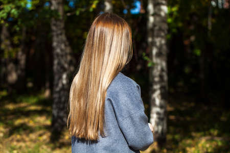 Full body portrait of a young beautiful girl in an autumn parkの写真素材