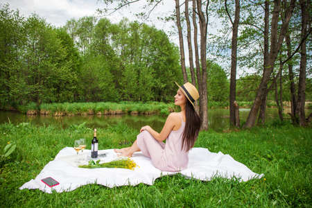 Young beautiful brunette woman in a turquoise summer dress, summer park outdoorsの写真素材