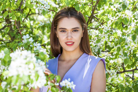 Portrait of a young beautiful brunette woman in beige dress