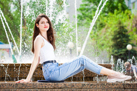 Young beautiful girl with a book resting in a summer parkの写真素材