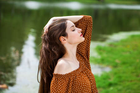 Young beautiful girl with a book resting in a summer parkの写真素材