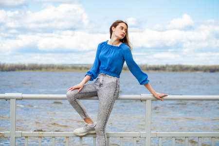 Collage four Fashion models in white coat and denim overalls posing in an amusement parkの写真素材