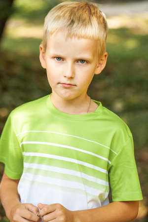 Close-up portrait of a little boy in a summer park