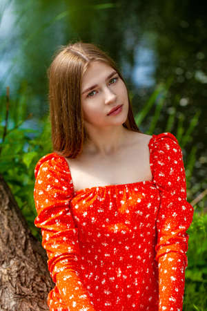Close up portrait of a young beautiful brunette woman in summer park