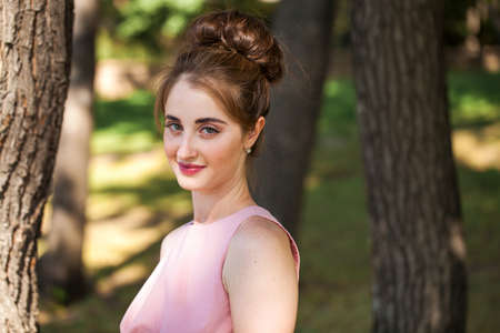 Full length portrait of young beautiful brunette woman in pink dress