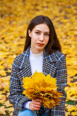 Portrait of a young beautiful brown-haired girl with freckles on her faceの写真素材