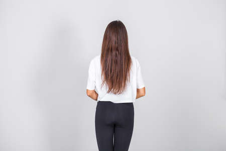 Full body portrait of a young beautiful brunette model, isolated on gray backgroundの写真素材