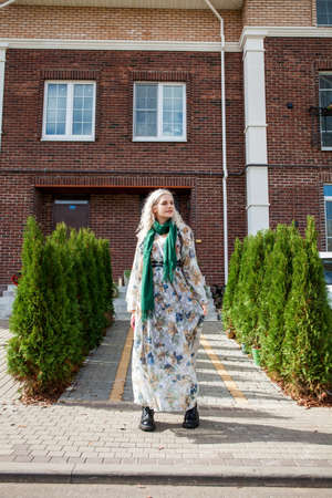 Portrait of young blonde woman posing on a wooden wall backgroundの写真素材