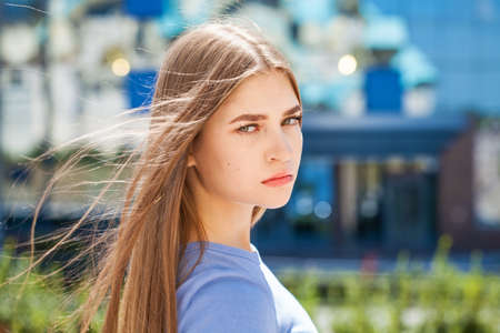 Back rear view blonde hair model in blue jeans, summer park outdoor