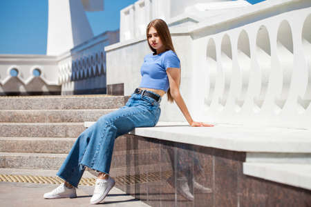 Back rear view blonde hair model in blue jeans, summer park outdoorの写真素材