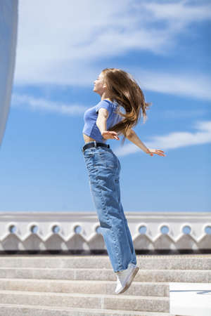 Back rear view blonde hair model in blue jeans, summer park outdoorの写真素材