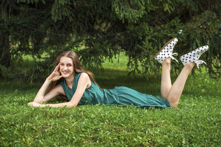 Full body portrait of a young beautiful brunette woman in green dressの写真素材