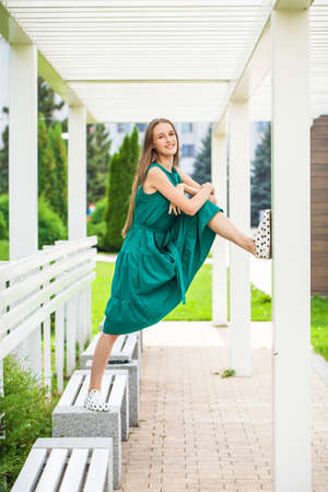 Full body portrait of a young beautiful brunette woman in green dressの写真素材