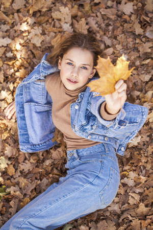 Young beautiful blonde girl lies on the lawn, summer park outdoorsの写真素材