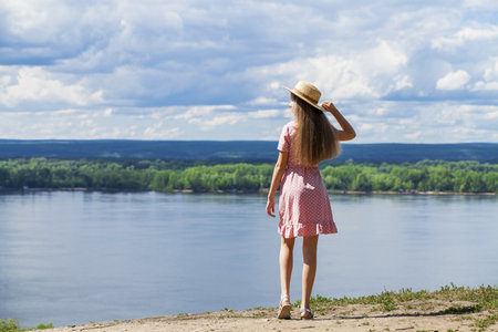 Young beautiful blonde girl lies on the lawn, summer park outdoorsの写真素材