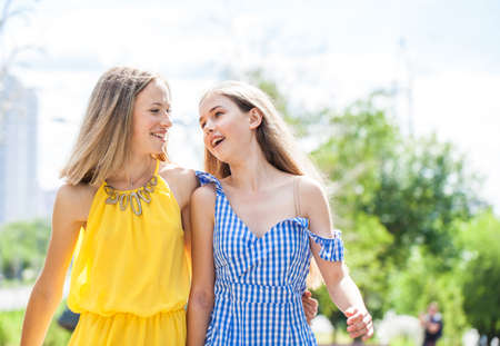 Young beautiful blonde girl lies on the lawn, summer park outdoorsの写真素材