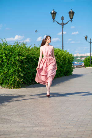 Full length portrait of young beautiful brunette woman in pink dressの写真素材