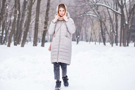 Close up portrait of young beautiful woman posing in winter parkの写真素材