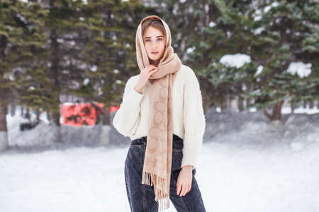 Close up portrait of young beautiful woman posing in winter parkの写真素材