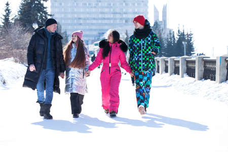 Happy family of four walking outdoors in winter