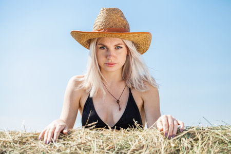 Portrait of a young beautiful blonde woman in a stylish spotted summer suitの写真素材