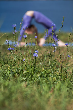 Young sports girl doing exercises with a skipping rope on a country roadの写真素材