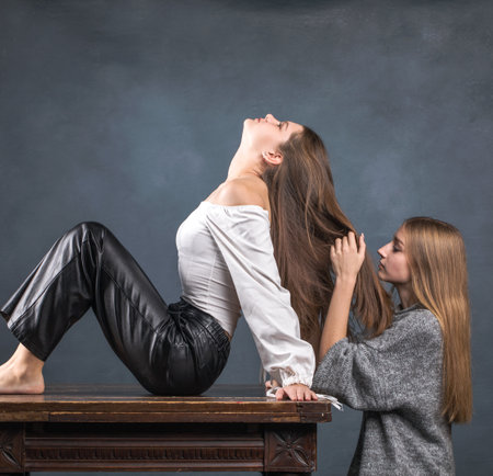 Brunette and blonde posing in dark studioの写真素材