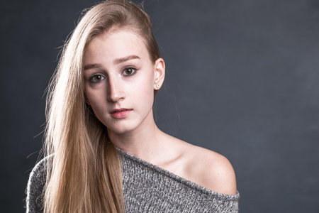 Close up portrait of a young beautiful blonde girl - isolated on blue backgroundの写真素材