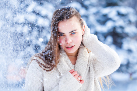 Portrait of a young beautiful brunette woman in white sweaterの写真素材