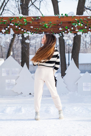 Full length portrait of young beautiful girl posing in winter parkの写真素材