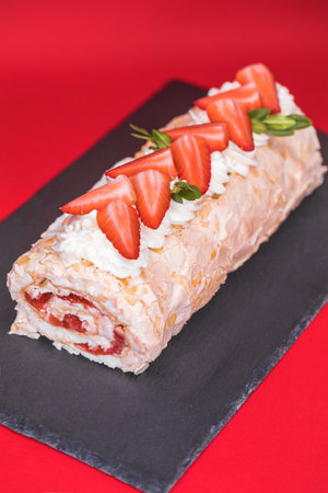 Homemade Meringue roll garnished with strawberry slicesの写真素材