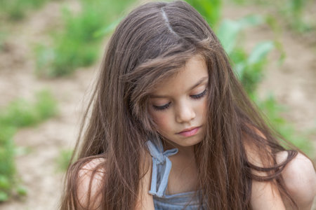 Portrait of a young beautiful preschool girl in a summer park