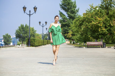 Young beautiful brunette woman in green dressの写真素材