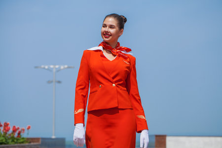 RUSSIA, SAMARA: 08 AUGUST 2022. Beautiful stewardess dressed in official red uniform of Aeroflot Airlines, Summer street outdoorsのeditorial素材