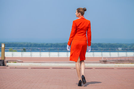 RUSSIA, SAMARA: 08 AUGUST 2022. Beautiful stewardess dressed in official red uniform of Aeroflot Airlines, Summer street outdoorsのeditorial素材