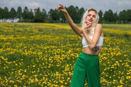 Portrait of a young beautiful girl posing in a spring field of dandelionsの写真素材