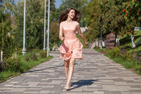 Full length portrait of a young beautiful woman in a pink dressの写真素材