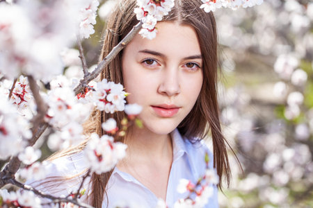 Close up portrait of a young beautiful girl in a blooming garden