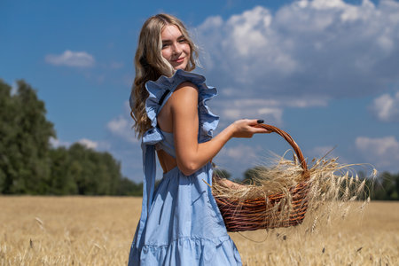 Portrait of a young beautiful blonde woman posing in a wheat fieldの写真素材
