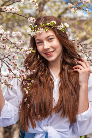 Close up portrait of a young beautiful girl in a blooming gardenの写真素材