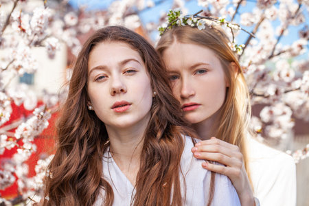 Close up portrait of a young beautiful girls in a blooming gardenの写真素材